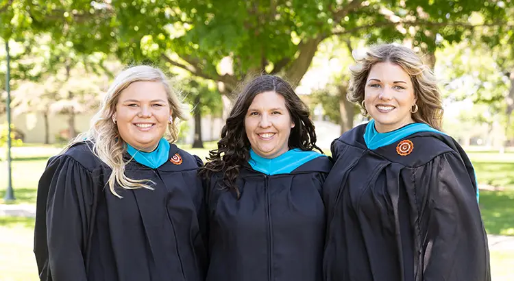 Graduate students in their robes on the campus mall